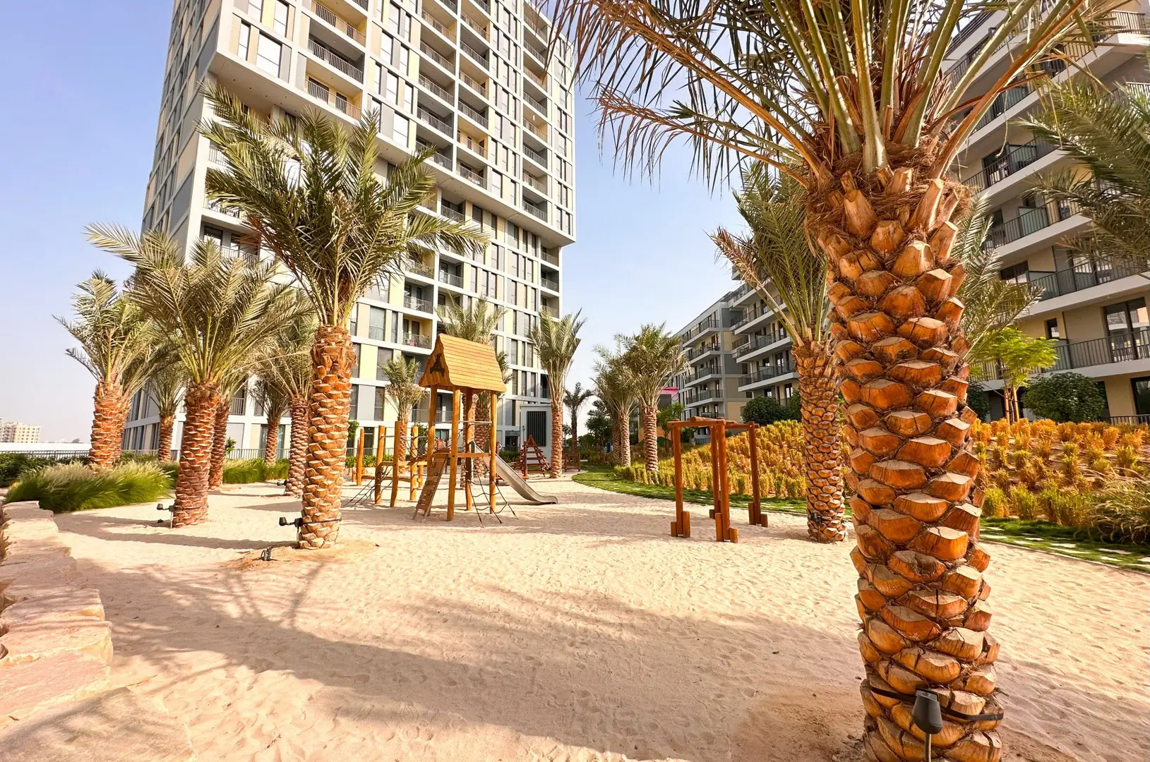 Noor buildings behind the palm garden and the play sand at Midtown